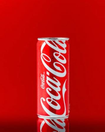 A Coca-Cola can in front of a red background