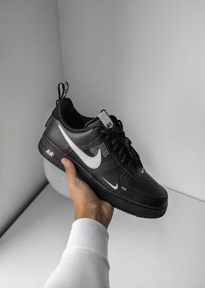 Person-holding-a-black-and-white-Nike-Air-Force-1-sneaker